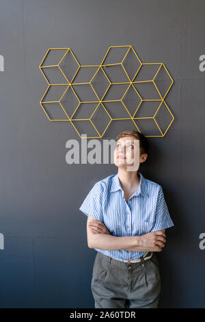 Frau, die unter einer Struktur an einer Wand Stockfoto