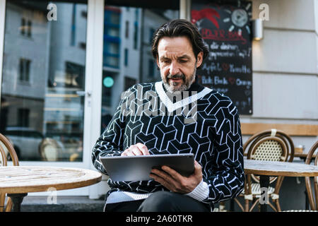 Portrait von modischen reifer Mann mit digitalen Tablette Cafe Stockfoto