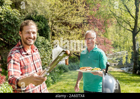 Portrait von glücklichen Mann auf einer Familie Grill im Garten Stockfoto