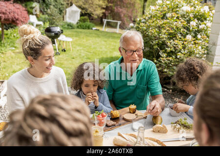 Erweiterte Familie beim Mittagessen im Garten Stockfoto