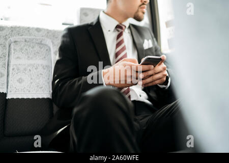 In der Nähe - upof junge Unternehmer mit Handy in ein Taxi Stockfoto