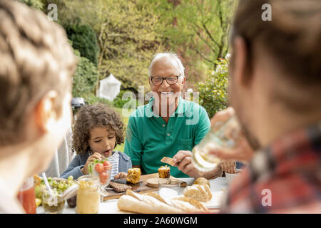 Erweiterte Familie beim Mittagessen im Garten Stockfoto