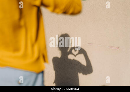 Schatten einer Frau Gestaltung ein Herz mit ihren Händen Stockfoto