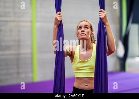 Junge Frau Vorbereitung auf Antenne Seide in einen Übungsraum Stockfoto