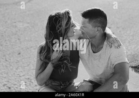 Herzlichen junges Paar am Strand zu sitzen Stockfoto