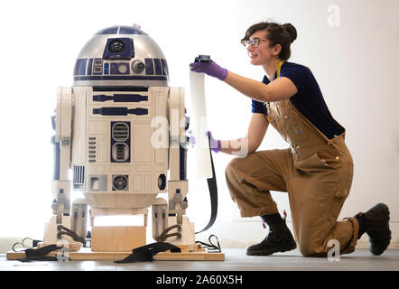 Museum Techniker Jessie Giovane Staniland prüft die original R2-D2, in den Star Wars Film 1977 verwendet, wie es bei der V&A Dundee, wo es das Herzstück der bevorstehenden Hallo, Roboter Ausstellung ankommt. Stockfoto