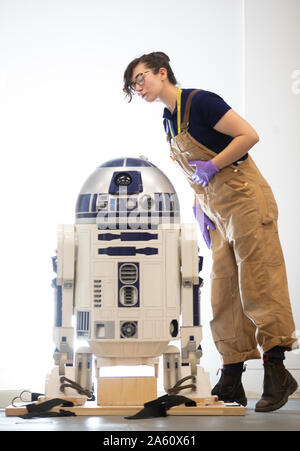 Museum Techniker Jessie Giovane Staniland prüft die original R2-D2, in den Star Wars Film 1977 verwendet, wie es bei der V&A Dundee, wo es das Herzstück der bevorstehenden Hallo, Roboter Ausstellung ankommt. Stockfoto