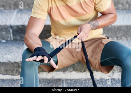 Nahaufnahme der Boxer sitzt auf der Treppe bandage Anwendung Stockfoto