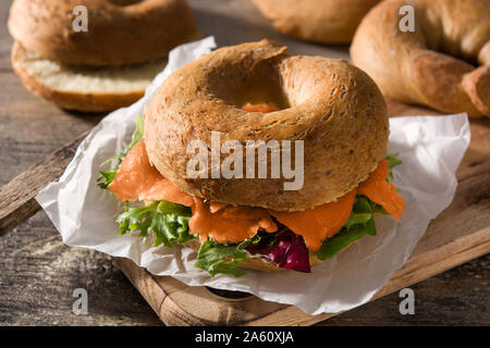 Sandwich Bagel mit Frischkäse, Lachs und Gemüse auf hölzernen Tisch Stockfoto