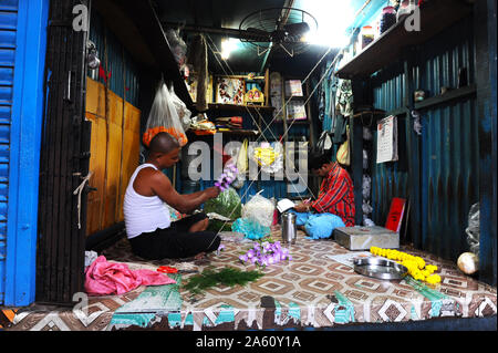Zwei Männer in Malik Ghat Blumenmarkt threading floralen Girlanden, Kolkata, West Bengal, Indien, Asien Stockfoto