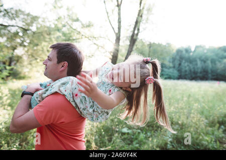 Vater, die verspielten Tochter auf seinen Schultern Stockfoto