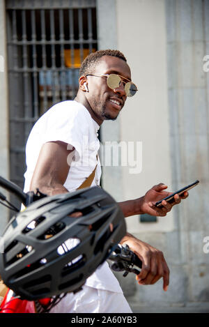 Junger Mann auf seinem Fahrrad mit seinem Smartphone Stockfoto