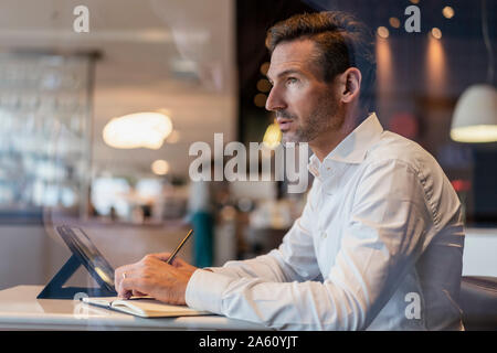 Geschäftsmann mit Tablette in ein Cafe Notizen Stockfoto