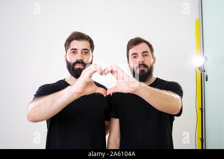 Homosexuelle Paare bilden Herzform mit Händen und Fingern. Stockfoto