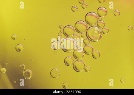 Schöne Mischen von Wasser und Öl auf einem gelben Hintergrund. Stockfoto
