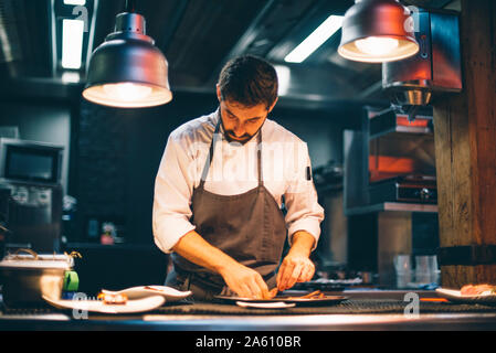 Koch das Essen auf den Tellern in der Küche eines Restaurants Stockfoto