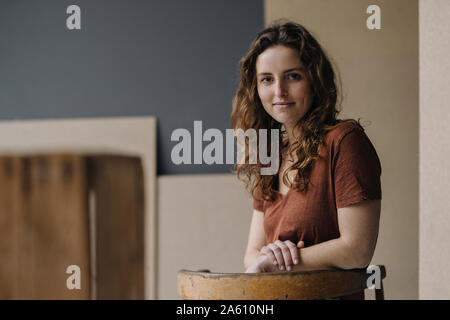 Portrait von lächelnden jungen Frau lehnte sich auf der Rückenlehne Stockfoto