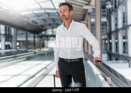 Geschäftsmann auf fahrsteig am Flughafen Stockfoto