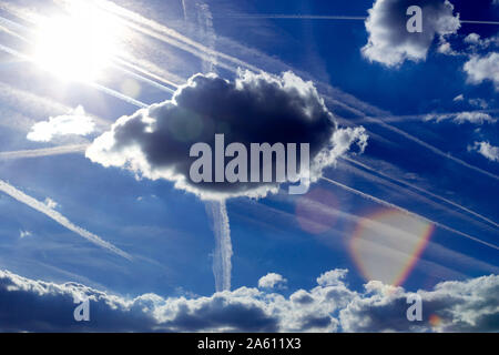 Blauer Himmel mit Wolken, Sonne und Kondensstreifen Stockfoto