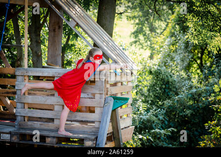 Superhelden Mädchen spielen in einem Baumhaus Stockfoto