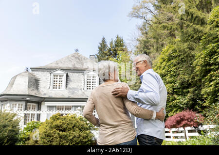 Ansicht der Rückseite des Senior Paar stehen im Garten ihres Hauses Stockfoto