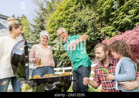 Erweiterte Familie grillen im Garten Stockfoto