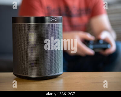 Großbritannien, Oktober 2019: Sonos spielen schwarz Wireless Speaker mit Gamer im Hintergrund Stockfoto