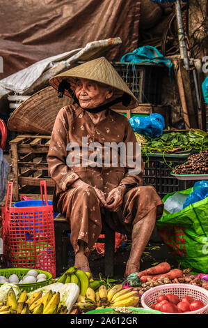 Hoi An/Vietnam - 06. März 2019: Eine alte Frau Verkauf von Obst und Gemüse zu einem lokalen Markt. Stockfoto