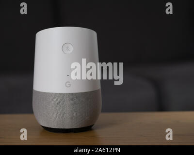 Großbritannien, Oktober 2019: Google Home smart Lautsprecher auf hölzernen Tisch in der Lounge Stockfoto