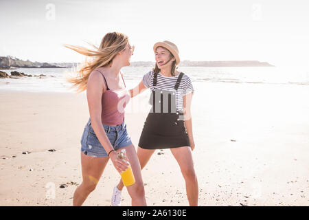 Zwei Freundinnen Spaß, Laufen und Springen am Strand Stockfoto