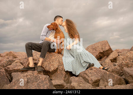 Junges Paar mit Hund am Strand Stockfoto