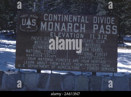 Schild "Monarch Pass on the Continental Divide", durch die Rocky Mountains in Colorado, mit Text, der Höhenangaben und Informationen über den National Forest Service, 1965 enthält. () Stockfoto