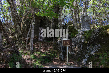 Buddha Statue Nummer 4 mit Erläuterungen Zeichen des Buddha Pfad auf den Gipfel des Mount Tsurumi. Beppu, Oita Präfektur, Japan. Stockfoto