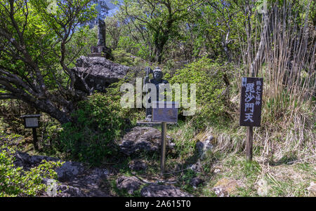 Buddha Statue Nummer 7 mit Erläuterungen Zeichen des Buddha Pfad auf den Gipfel des Mount Tsurumi. Beppu, Oita Präfektur, Japan. Stockfoto