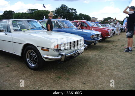 Zwei Menschen bewundern eine Reihe von Oldtimern, die auf der Oldtimerausstellung an der englischen Riviera, Paignton, Devon, England, Großbritannien, ausgestellt sind. Stockfoto