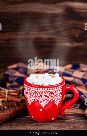 Rot Tasse mit Kakao und Marshmallows, Dampfbad, geformt wie ein Herz mit gemütlichen Plaid Stockfoto
