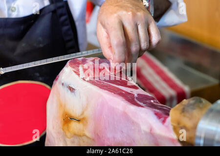 Metzger schneiden Scheiben eines spanischen Iberian Serrano Schinken Stockfoto