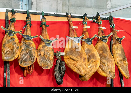 Aracena, Huelva, Spanien - Oktober 20, 2019: Aussteller der ausgehärteten Iberico Schinken Schwein in 2019 iberischer Schinken Messe von Aracena Stockfoto