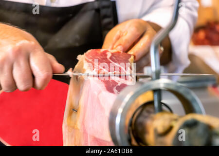 Metzger schneiden Scheiben eines spanischen Iberian Serrano Schinken Stockfoto