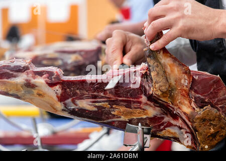 Metzger schneiden Scheiben eines spanischen Iberian Serrano Schinken Stockfoto