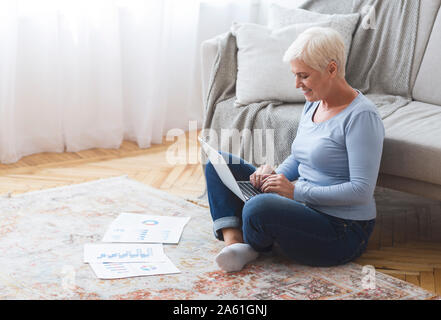 Im Alter von weiblichen Unternehmer, die von zu Hause aus arbeiten, mit Laptop Stockfoto