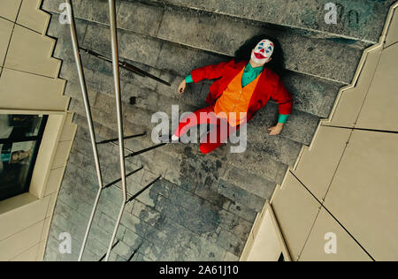 Dnipro, Ukraine - Oktober 22, 2019: Cosplayer in das Bild eines Verrückten clown Arthur Fleck aus dem Psychologischen Thriller 'Joker' läuft die Treppe hinunter. Stockfoto