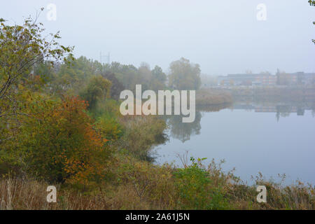 Schöne Landschaft, herbstliche Natur mit weißen dichten Nebel über Karriere See, Dnipro Stadt, in der Ukraine. Stockfoto
