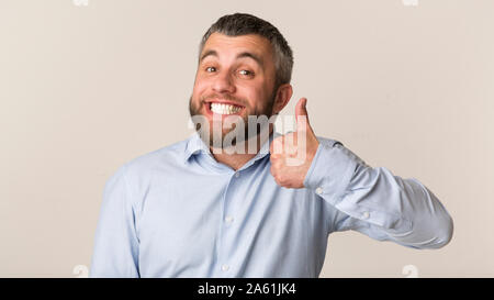 Happy bärtiger Mann mit Daumen hoch und lächelte Studio Stockfoto