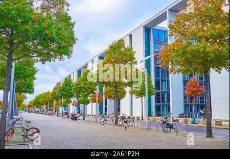 BERLIN, DEUTSCHLAND - 3. OKTOBER 2019: Die Wander- Gasse mit Linien der Bäume im Herbst neben der großen modernen Paul-Lobe Haus, die Regierung buildin Stockfoto