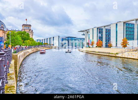 BERLIN, DEUTSCHLAND - 3. OKTOBER 2019: Zahlreiche Sehenswürdigkeiten touristische Boote segeln entlang der Spree im Regierungsviertel unter historischen und modernen buildin Stockfoto