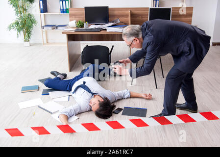 Die forensische Ermittler und tote Mitarbeiter im Büro Stockfoto