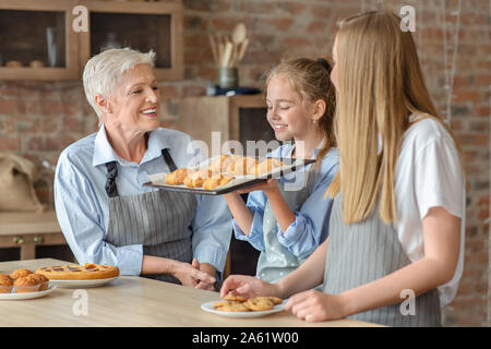 Fröhliches Mädchen Holding und riechen frisch gebackene Croissants Stockfoto