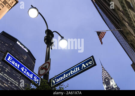 Juli 2018. Schöne Nacht geschossen in Manhattan, New York City (NY). Eine US-Flagge ist sichtbar, sowie Straßenlaternen, Straßenschilder (East 42th St) Stockfoto