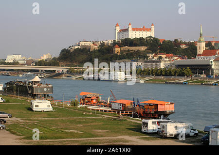 BRATISLAVA, SLOWAKEI - 01 September, 2019: Travel trailers am Ufer der Donau, Brücke SNP (links), die Donau und die Burg von Bratislava (rechts). Stockfoto